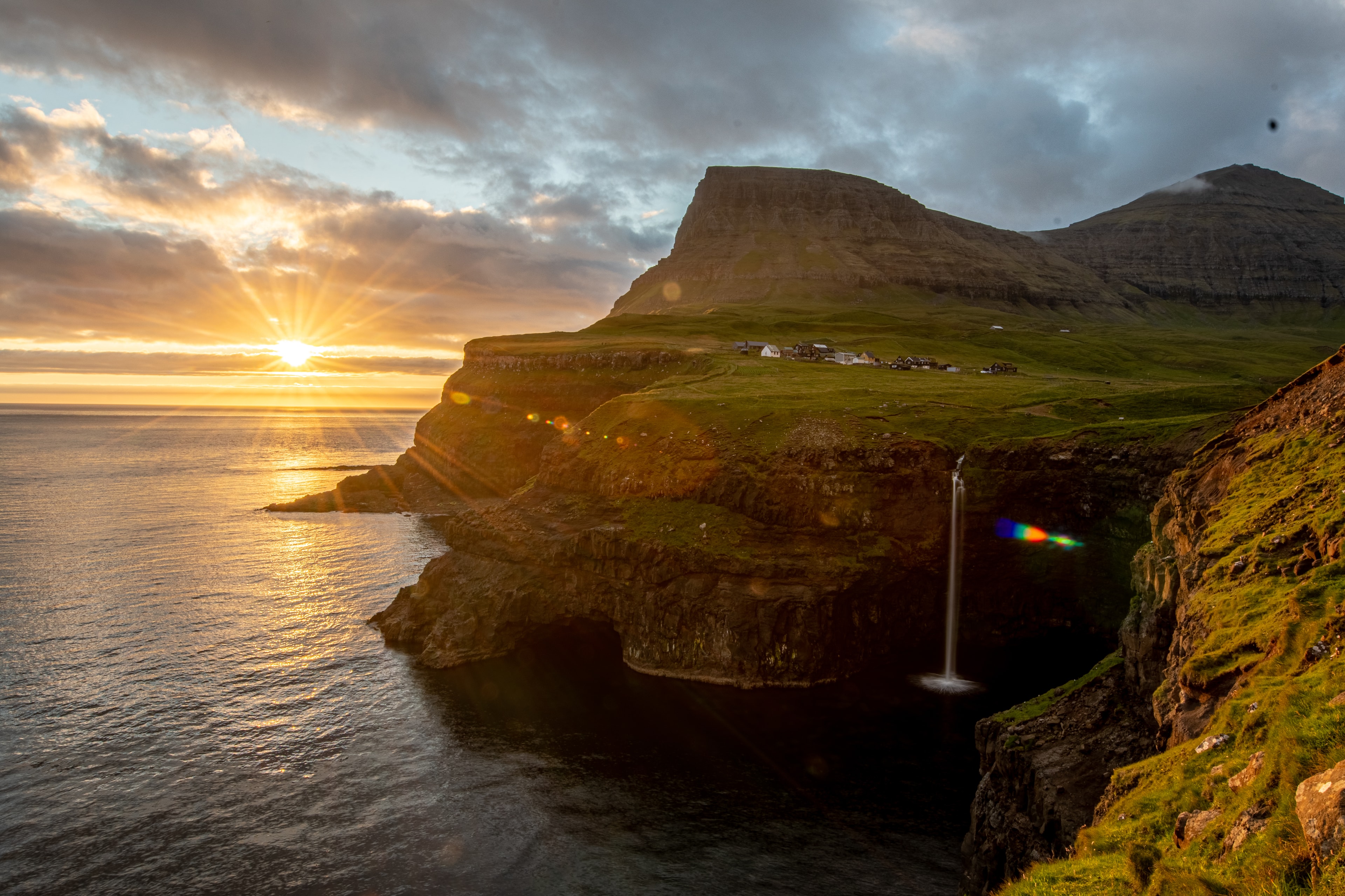 Coastal landscape at dawn with golden light illuminating the shoreline and ocean waves